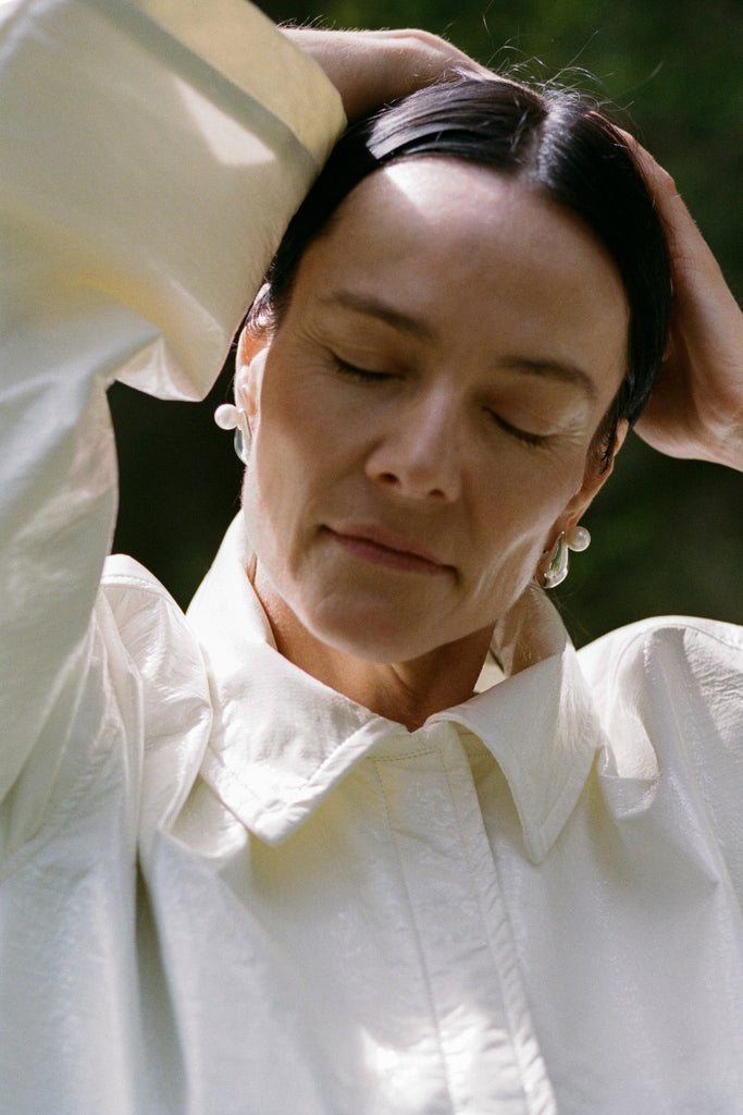 Mood shot of Aubergine Astrid earring with freshwater pearl – sculptural aubergine-shaped jewelry design by ANNE MANNS