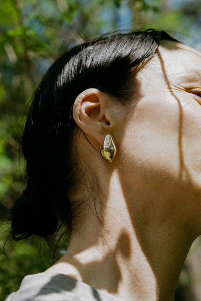 Side view of small Aubergine earring in gold – bold sculptural jewelry design by ANNE MANNS